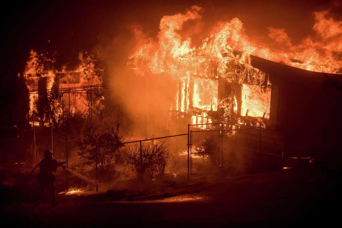 Flames from a wildfire consume a residence near Oroville, Calif., on Sunday.