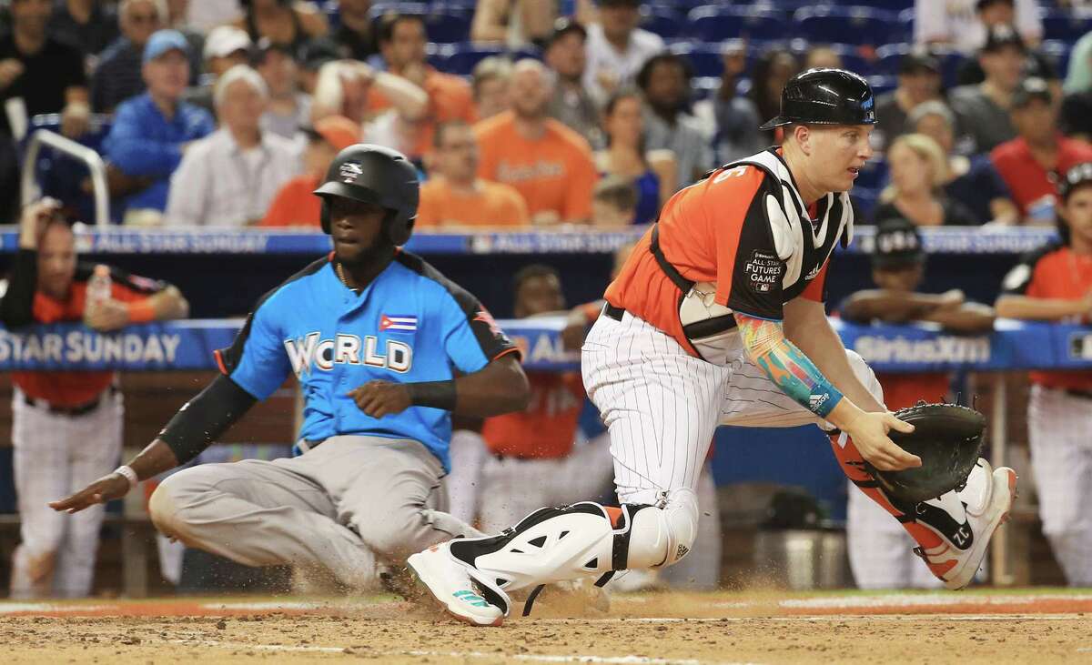 Astros first-base prospect Yordan Alvarez, left, slides in safely past White Sox catching prospect Zack Collins during the Futures Game in Miami.