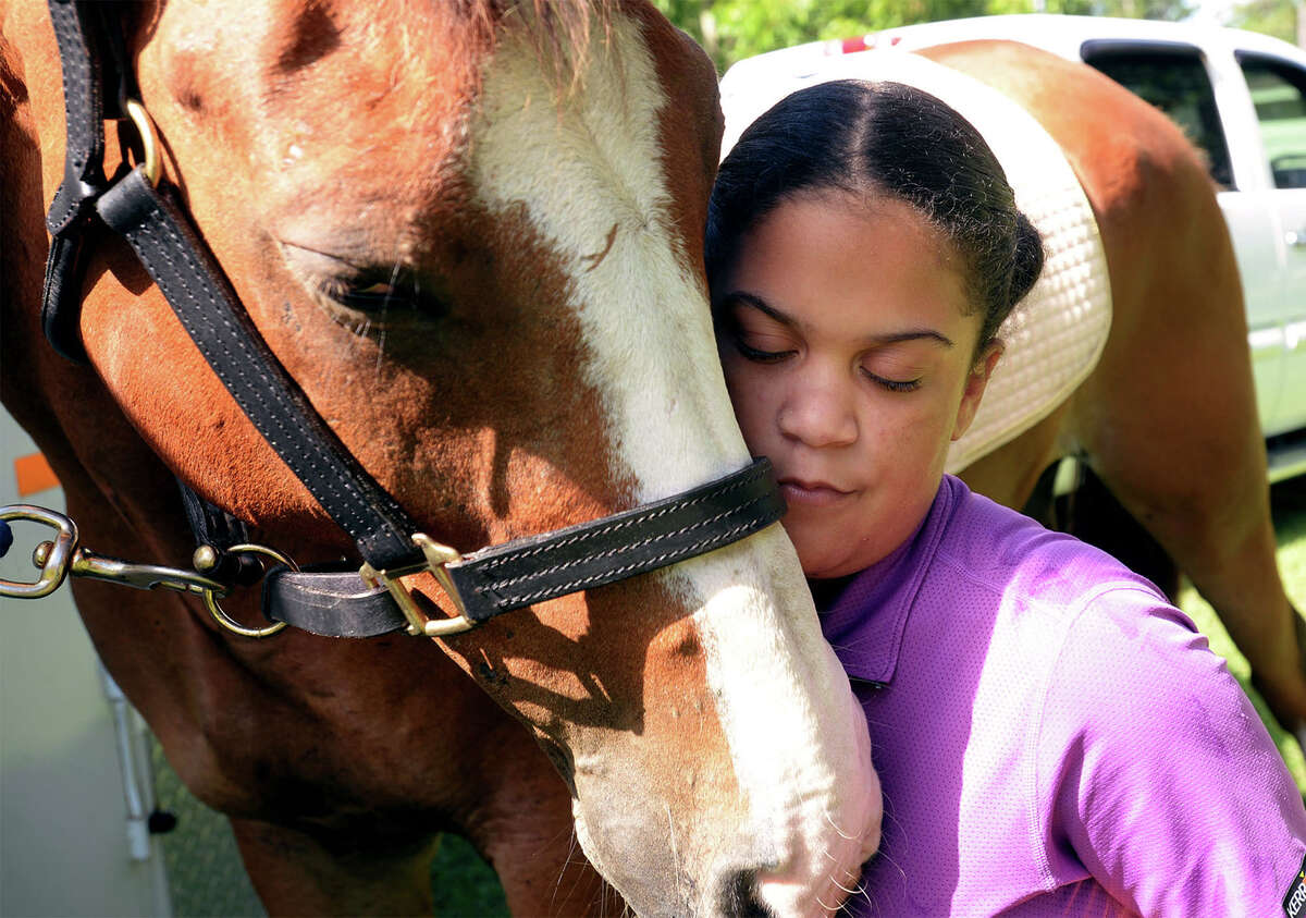 Hailey Hayes hugs, on Friday, Pistol a 10-year-old mixed breed who was stolen earlier this week and later reclaimed. Pistol who is trained as a therapy horse was recovered in Louisiana and has returned to helping Hayes combat the effects of Devic's disease which effects her optical and spinal nerves. Photo taken Friday, July 07, 2017 Guiseppe Barranco/The Enterprise