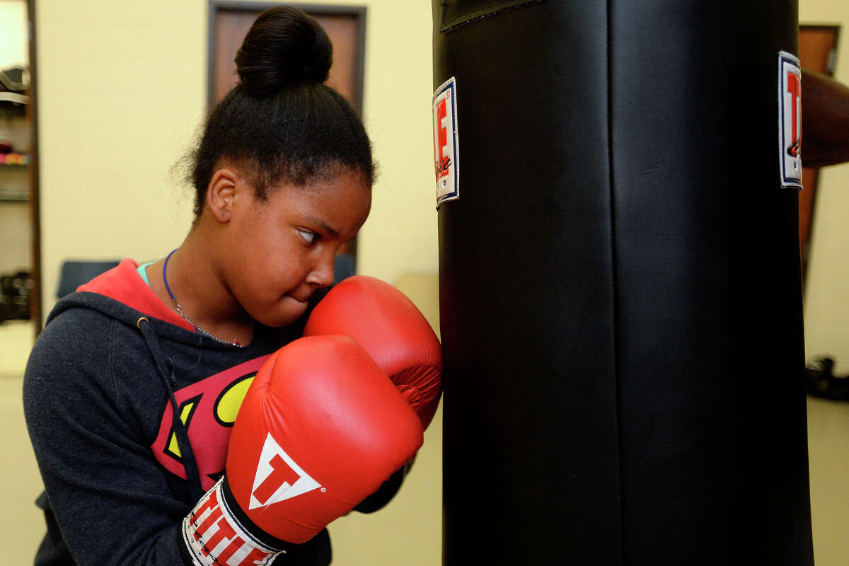 I'yanna Gatheright, 11, practices hitting a punching bag during boxing training at Beaumont's Sterling Pruitt Activity Center on Wednesday evening. Photo taken Wednesday 7/5/17 Ryan Pelham/The Enterprise