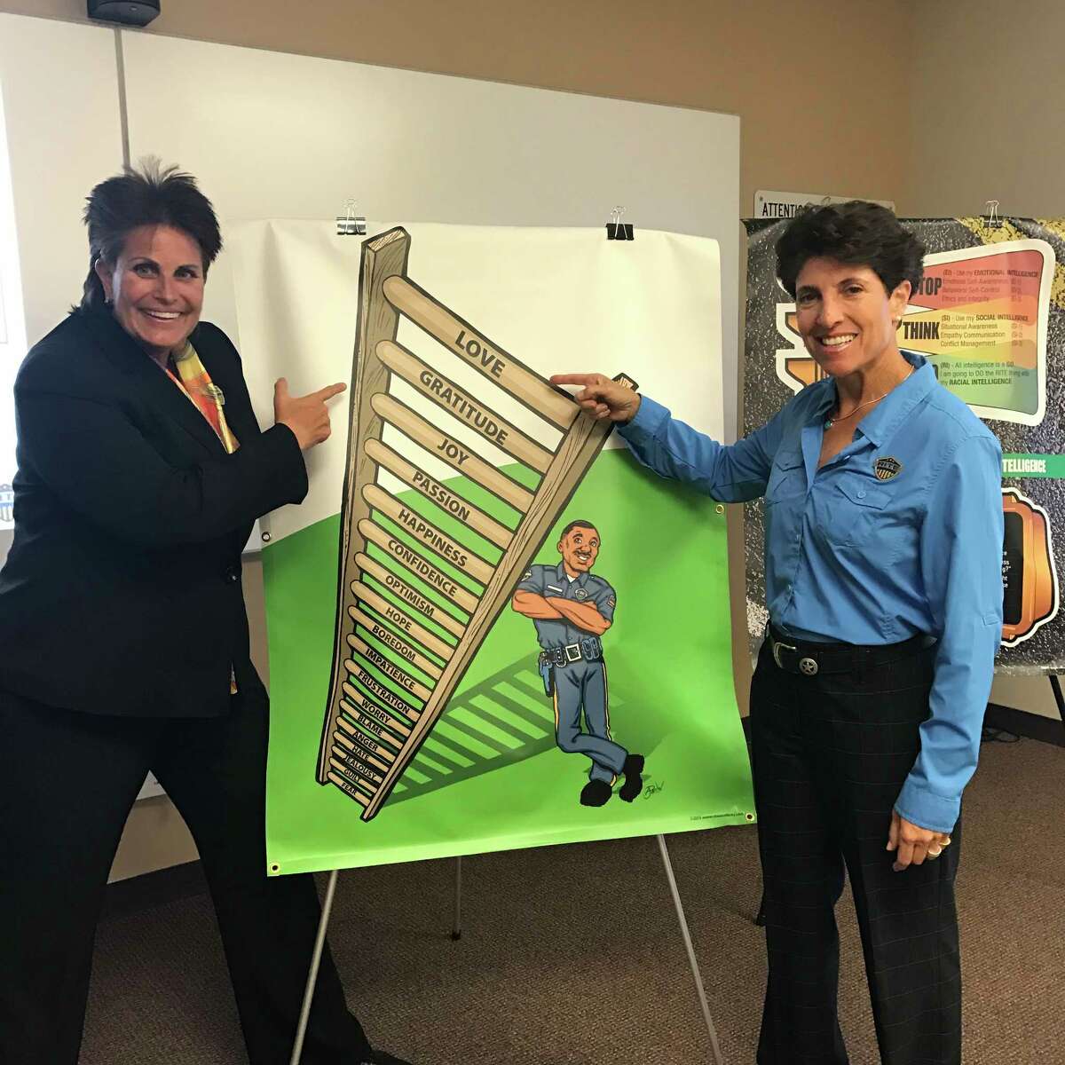 Linda Webb and Randy Friedman, co-founders of Racial Intelligence Training and Engagement Academy, stand with their training curriculum poster of the 18-tier emotion ladder at a training in Missouri City on June 7, 2017.