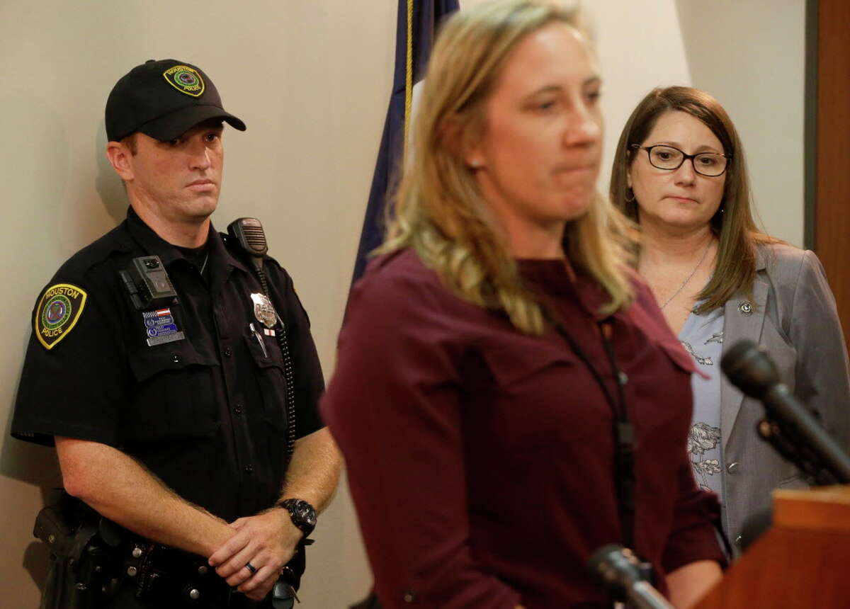 Houston Police Officer Chris Meade, left, listens as HPD Lt. Jessica Anderson, center, speaks along with JoAnne Musick, right, of the Harris County District Attorney, during a media conference at the District Attorney office,1201 Franklin, Monday, July 10, 2017, in Houston. Officer Meade discovered a box truck Sunday afternoon with a dozen persons, including a minor girl, locked inside the cargo bay. All of the persons who were smuggled are believed to be from Latin America. Three people are charged with human smuggling in the case. They are Priscila Perez Beltran, 21, Adela Alvarez, 26, and Nelson Cortes Garcia, 27.