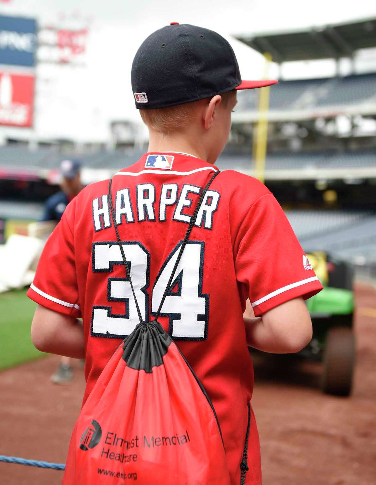 A Washington Nationals fan wears a Bryce Harper jersey before a baseball game between the Washington Nationals and the Atlanta Braves, Thursday, July 6, 2017, in Washington. Harper, Mike Trout and Aaron Judge have become the face of baseball as a gleaming, modernist ballpark and a city known for its Latino culture host the All-Star Game for the first time. (AP Photo/Nick Wass) ORG XMIT: NY152