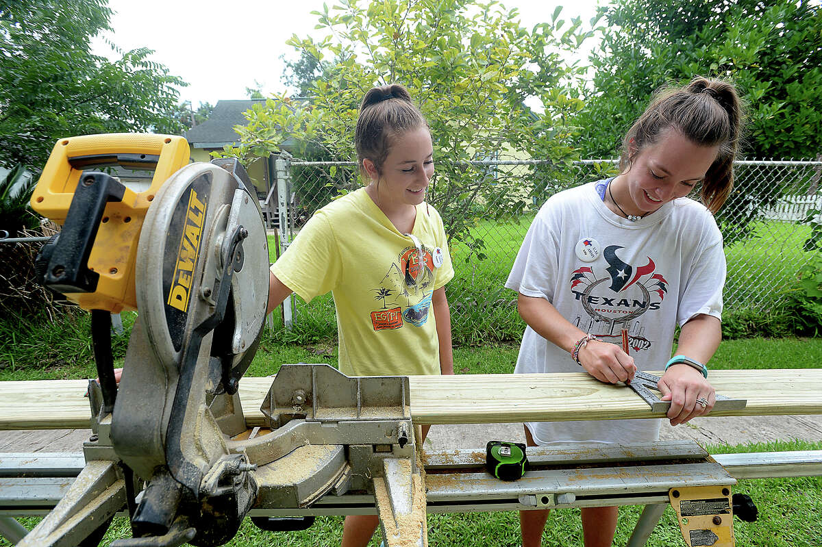 Logan Armstrong jokes with Lily Sanders as they continue cutting boards to size while they and crew with this year's UMARMY (United Methodist Action Reach-out Mission) work on building a wheelchair ramp at a home in Beaumont Monday. The annual summer program, which is being hosted locally at Wesley United Methodist Church, brings together 60 youth and adult volunteers from three different regional United Methodist Church for a week. This year, members from Atascocita, Lufkin, and Angleton United Methodist Churches are working in Beaumont, helping to paint houses, do repair work, and build wheelchair ramps for 7 area clients in need of assistance. Photo taken Monday, July, 10, 2017 Kim Brent/The Enterprise