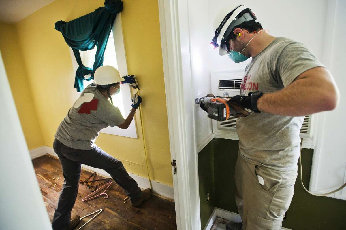 Volunteers with Team Rubicon work to gut the inside of the home of Peggy Sue and Mike Ginter, which was severely damaged by recent flooding, on Tuesday, July 11, 2017 on Atwell Street near Poseyville Road.