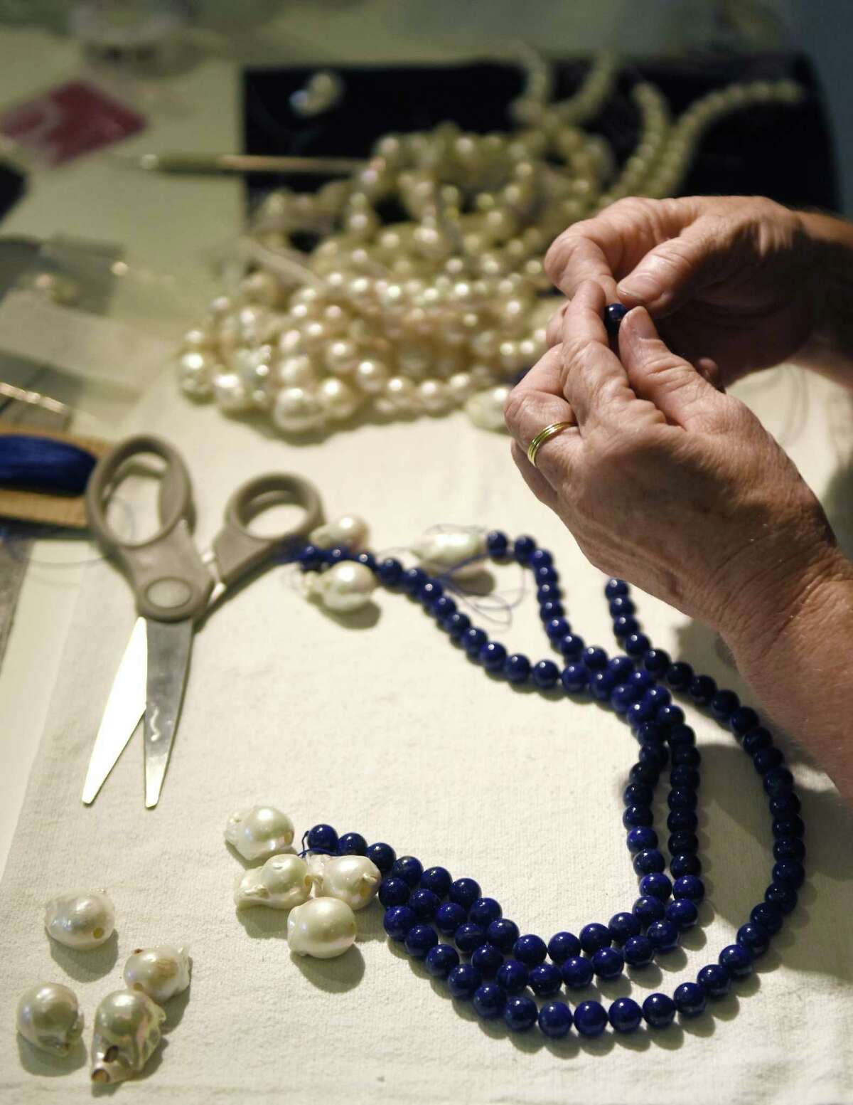 Expert pearl stringer Renee Courtney threads a pearl necklace at Barbara Harris Water Jewels in Greenwich, Conn. Monday, July 10, 2017. Courtney is working in the shop three days a week to customize, rework and restring jewelery for Harris and customers.