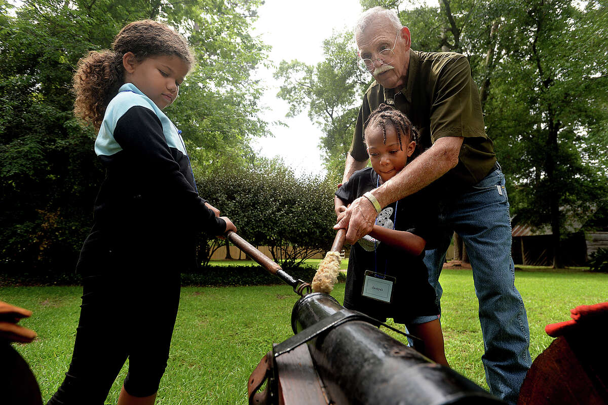 From left, Laila Brown, 7, and Janiyah Living, 7, take position under the guidance of Ron Schroeder as they and members of their group learn the steps to firing a canon, as would soldiers of the 1800's. The hands-on activity is among many planned for children in the Beaumont Heritage Society's annual Camp Lookinback, which began Tuesday. Held on the grounds of the John Jay French Museum, it offers a fun, educational look at the life and style of the 1800's, ranging from canon firing to crafts, and the work of war time lady spies to cooking. Photo taken Tuesday, July, 11, 2017 Kim Brent/The Enterprise