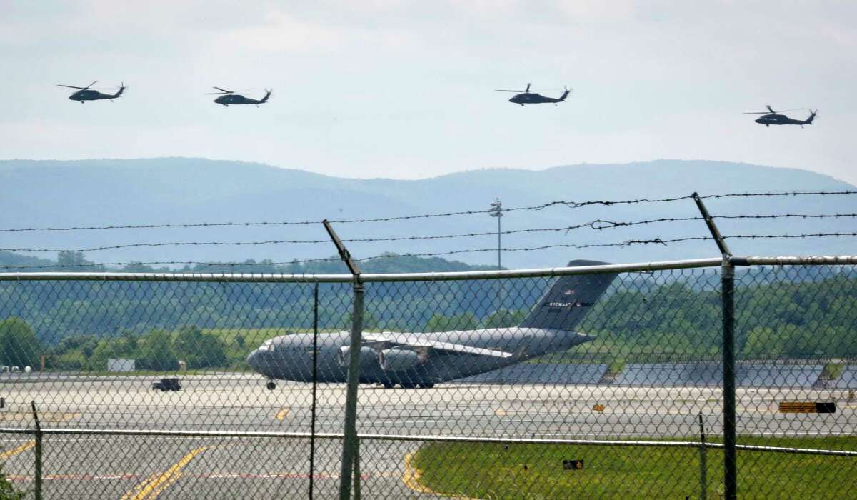 Helicopters fly above a military aircraft on the tarmac at the Stewart Air National Guard Base in Newburgh, N.Y., Tuesday July 11, 2017. Officials said a Marine Corps refueling plane that crashed and burned on Monday in the Mississippi Delta, killing all 16 military members aboard, was based at the Stewart Air National Guard Base in Newburgh. The victims' identities were not immediately released. (AP Photo/Bebeto Matthews)