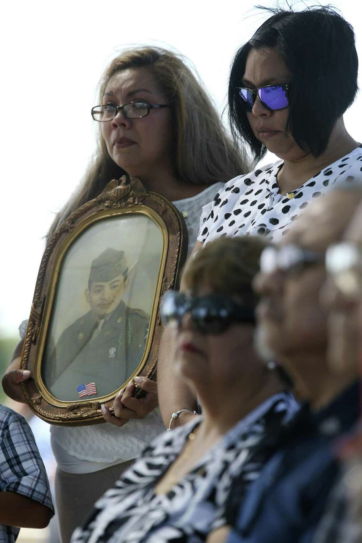 Melanie Sandoval Dacosta holds a portrait of her grandfather, U.S. Army Cpl. Frank Luna Sandoval, during his burial ceremony at Fort Sam Houston National Cemetery, Tuesday, July 11, 2017. Sandoval was missing action and presumed dead since the Korean War. Sandoval was 20-years-old when he was take as a prisoner of war and died of malnutrition. Sandoval was reported missing in action on Feb. 13, 1951 and declared dead over two and a half years later. He body was returned to U.S. custody in 1954 and he was buried as an unknown soldier in Hawaii for decades. The family was notified of his identification early this year.
