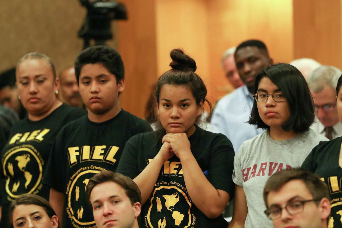 Daisy Garay, center, listens to speakers as she and others protest against SB4. Harris County Judge Ed Emmett cautioned against interpreting the commissioners' decision as an "endorsement" of the disputed law. ﻿