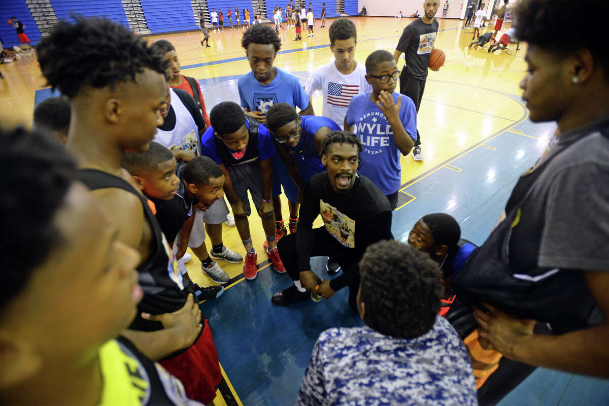 Kevin Newton huddles with participants of the Future Stars Basketball Summer Camp scrimmage during a break at Ozen High School on Monday. Among others Kris Richard, J'Covan Brown and Jamar Guillory were on hand to teach technique and work with the children. Photo taken Tuesday, July 11, 2017 Guiseppe Barranco/The Enterprise