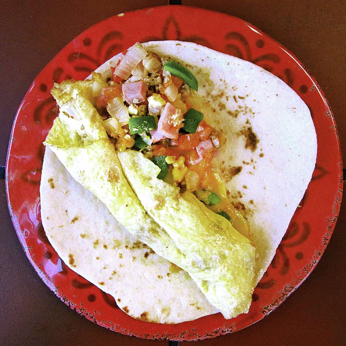 Omelet breakfast taco with eggs, ham, sausage, peppers, onions, tomatoes and cheese on a handmade flour tortilla from Ruthie's Mexican Restaurant.
