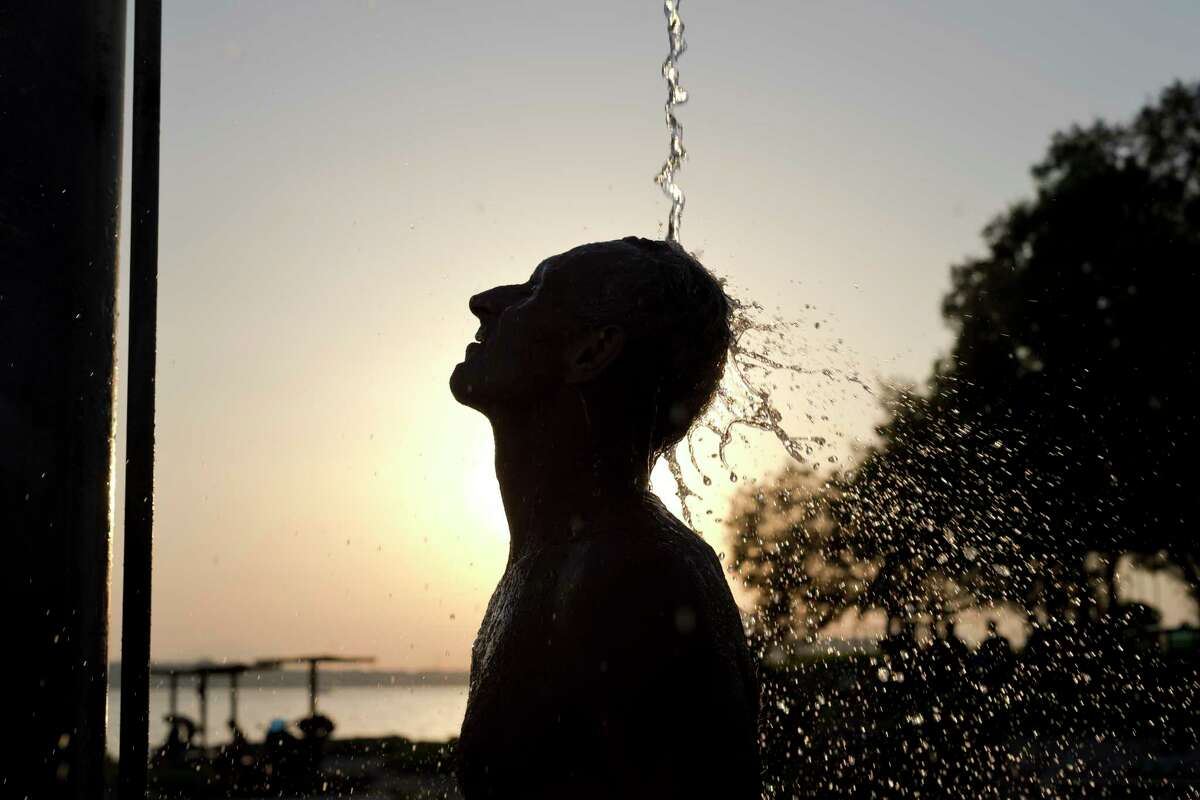 A man takes a shower at a beach of Alimos suburb, in Athens Wednesday, July 12, 2017. A summer heatwave has hit Greece, with temperatures reaching a high of 39 degrees Celsius (102 Fahrenheit) in Athens.(AP Photo/Petros Giannakouris)