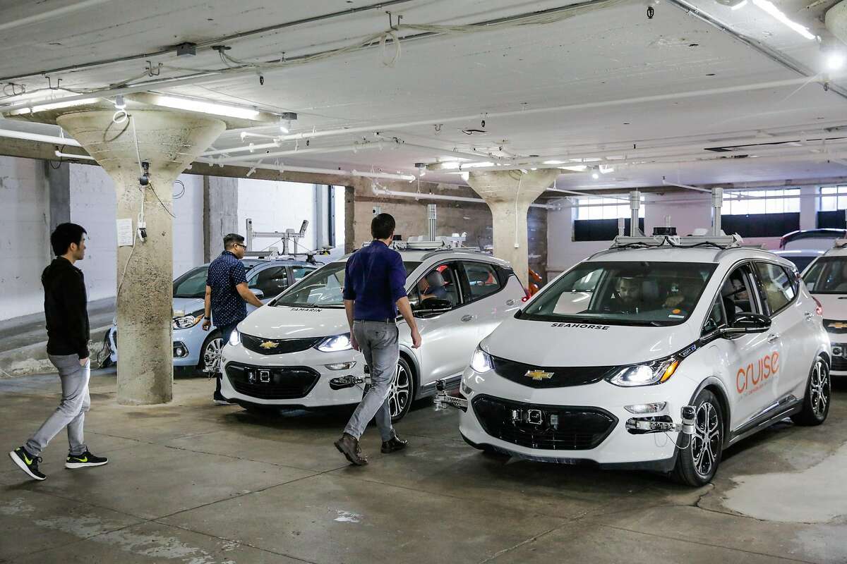 Autonomous vehicle trainer Alex Kexel (right) and operations team lead Roy Ysmael (second from left) prepare cars for test drives at Cruise Automation, an autonomous driving car company in the SOMA district of San Francisco, California, on Tuesday, March 14, 2017.