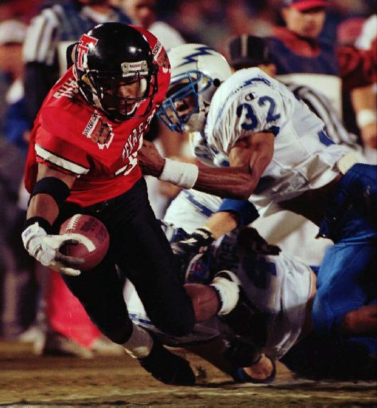 Texas Tech's Byron Hanspard (4) is tackled by Air Force's LeRon Hudgins (32) in early Copper Bowl action at Arizona Stadium in Tucson, Ariz., Wednesday, Dec. 27, 1995. Texas Tech downed the Falcon's 55-41.(AP Photo/Scott Troyanos)