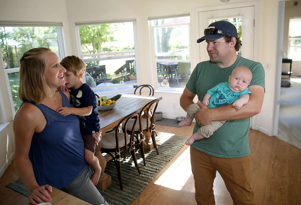 Bay area chefs Shauna Des Voignes (left) holds their two year old Henry Des Voignes and Jake Des Voignes (right) holds their 2 month old Leo De Voignes at home on their 20 acre farm and vineyard of orange musket on Monday, June 26, 2017, in Acampo, Calif.