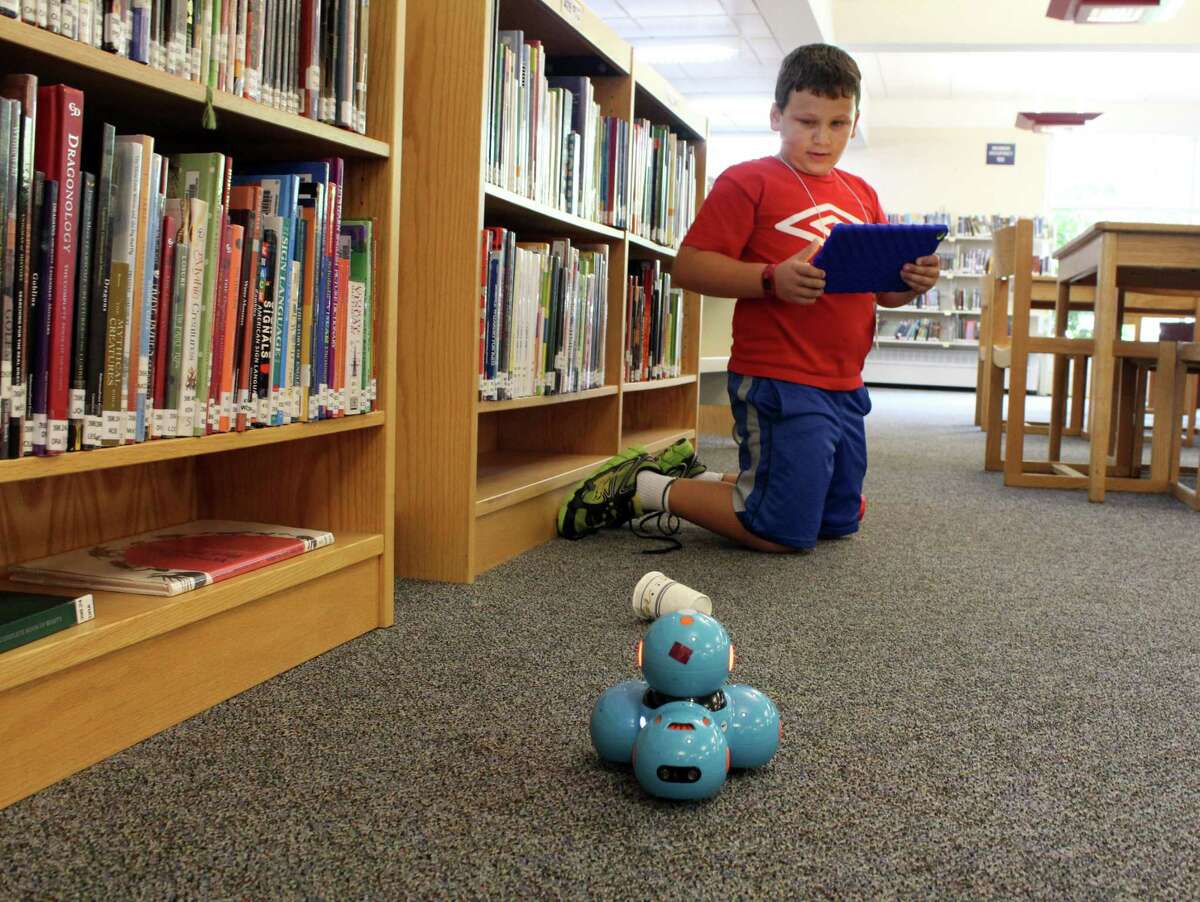 Noah van den Heuval, 8, plays with Dash robot at Wilton Continuing Education's coding, robotics and maker crafts summer camp on Wednesday, July 12, 2017.