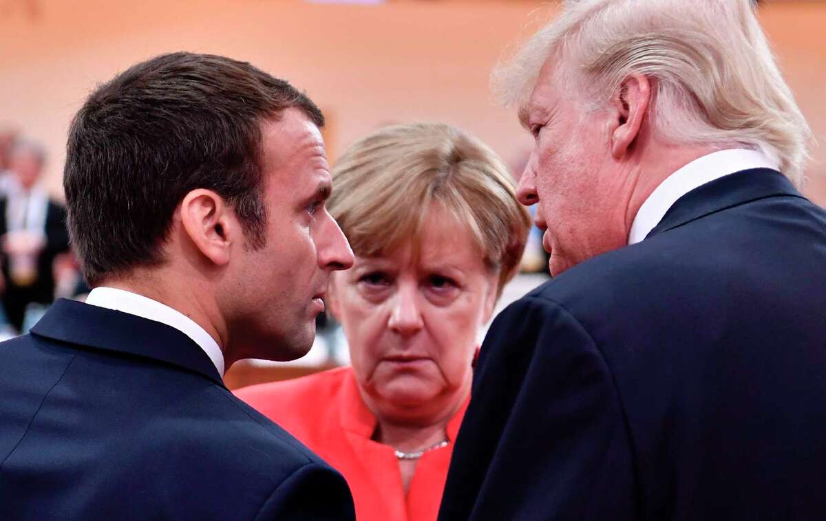 President Donald Trump, right, French President Emmanuel Macron, left, and German Chancellor Angela Merkel chat at the G20 meeting in Hamburg, northern Germany last week. (John MacDougall / AFP/Getty Images)
