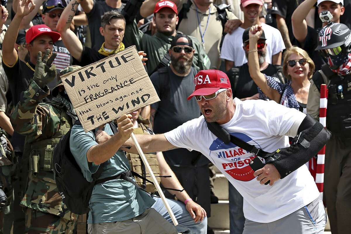 Kevin Kamath, left, and Kyle Chapman, right, get into an altercation at the Texas State Capitol during a march against President Trump, calling for his impeachment July 2 in Austin.