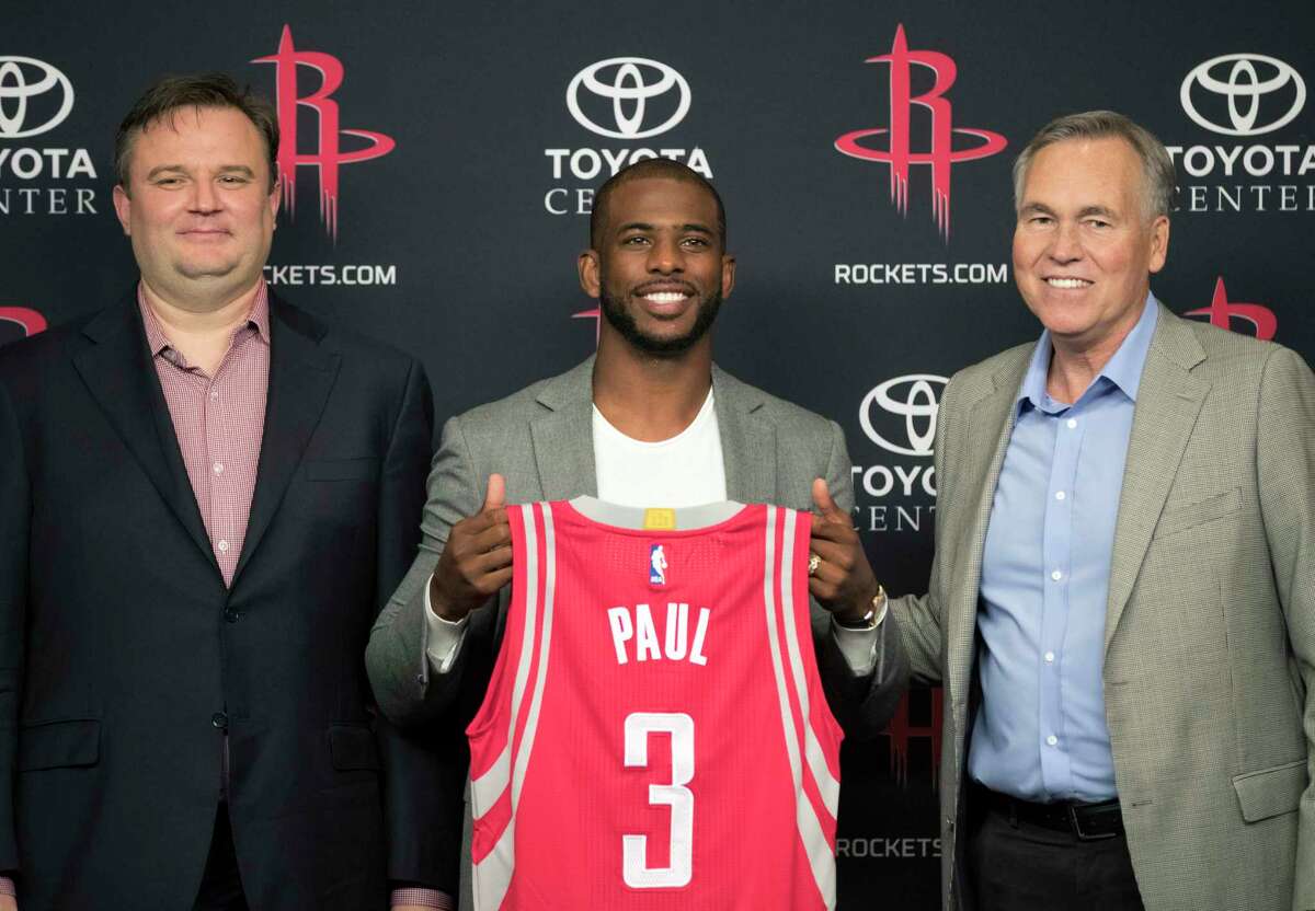 Chris Paul, center, holds his new jersey as he is joined by Houston Rockets general manager Daryl Morey, left, and coach Mike D'Antoni, right, during a news conference Friday, July 14, 2017, in Houston. The nine-time All-Star was traded from the Los Angeles Clippers late last month. (AP Photo/David J. Phillip)