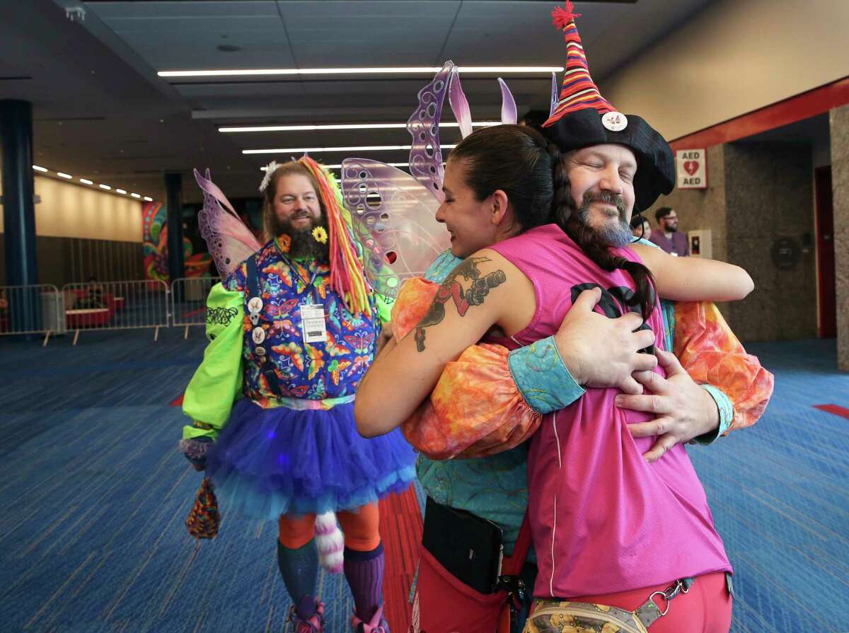 Dave Cline, as Dim of Dim n Wit, the Fairy Brothers, and Dave Bang, as Wit, take turns giving free hugs to Houston Roller Derby player Leanette "Smashvillain" McDougall at Comicpalooza Sunday, May 14, 2017, in Houston. ( Yi-Chin Lee / Houston Chronicle )