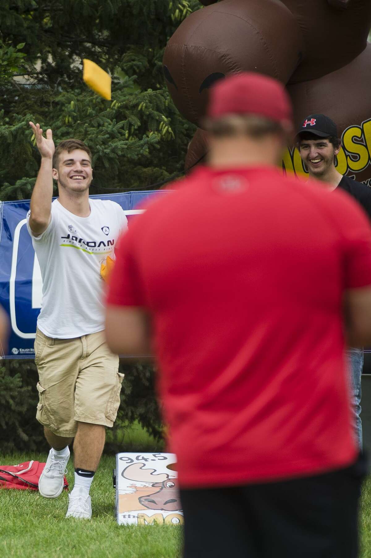 Chad Mielke of Beaverton, left, and Ronnie Remer of Beaveron, right, compete in a cornhole tournament during Riverdays on Friday.