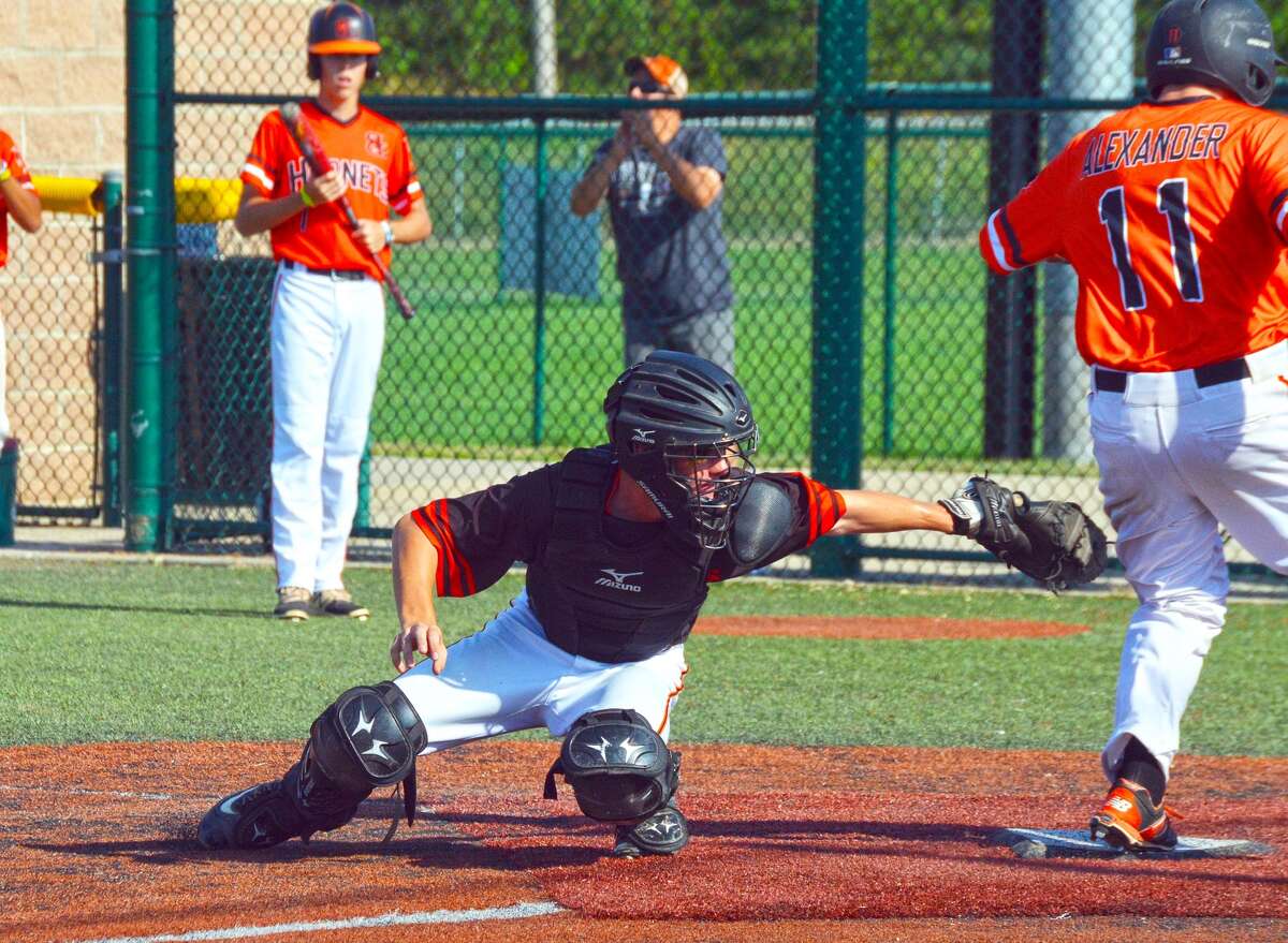 Edwardsville catcher Ben Basarich attempts a swipe tag during Friday’s game against the Hornets.