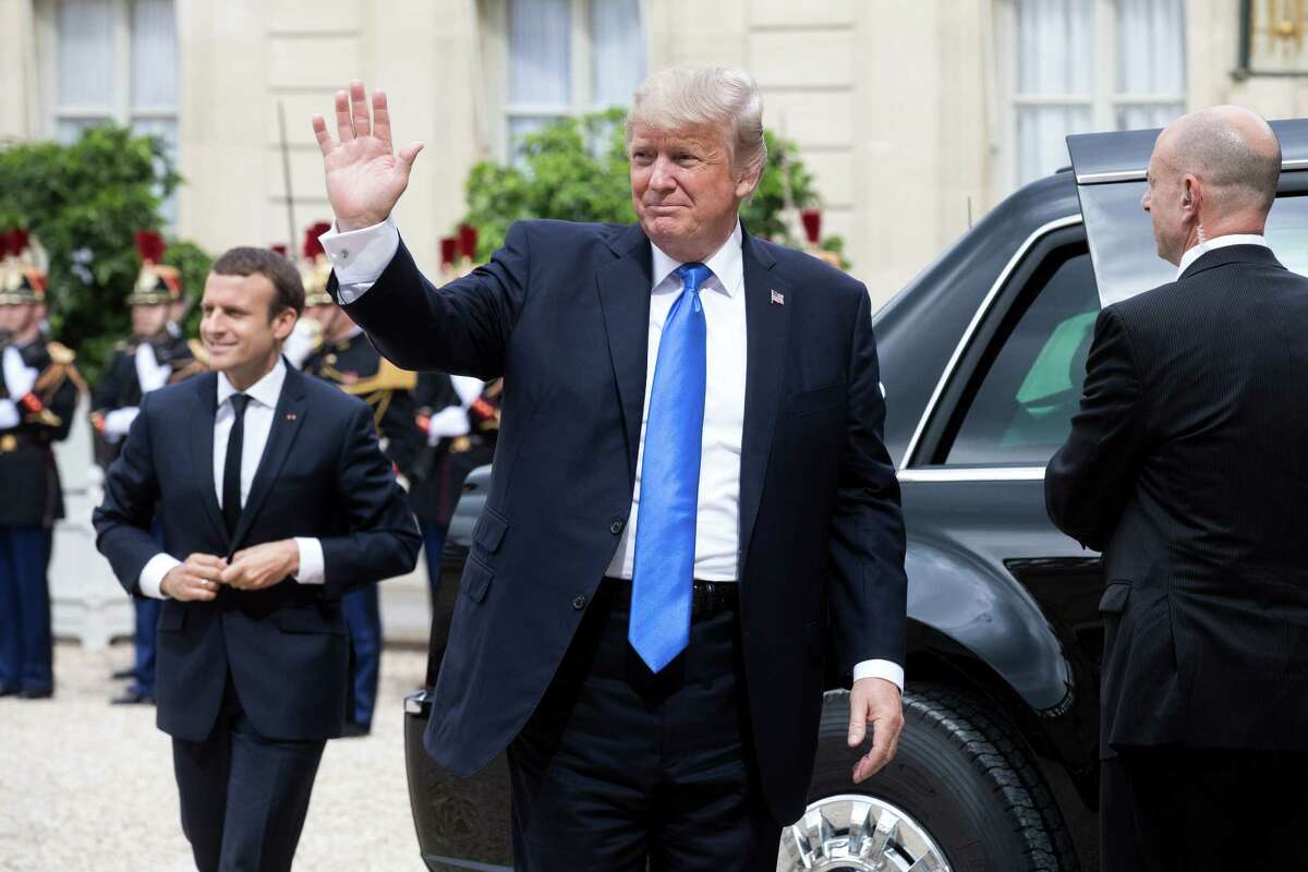 President Donald Trump waves as he arrives at the Elysee Palace in Paris on Thursday. (Christophe Morin / Bloomberg)