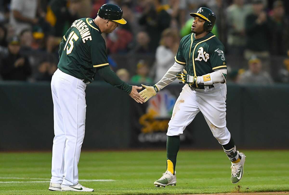 OAKLAND, CA - JULY 14: Rajai Davis #11 of the Oakland Athletics is congratulated by third base coach Steve Scarsone #15 after Davis hit solo home run against the Cleveland Indians in the bottom of the fifth inning at Oakland Alameda Coliseum on July 14, 2017 in Oakland, California. (Photo by Thearon W. Henderson/Getty Images)