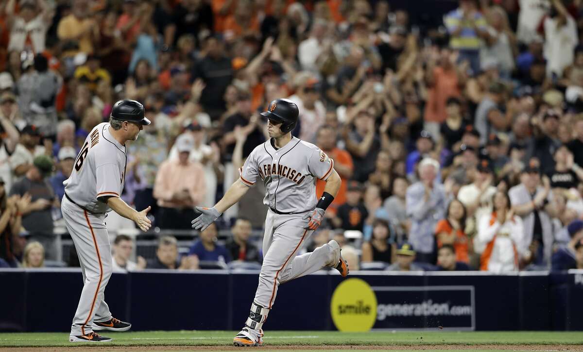 San Francisco Giants' Buster Posey is greeted by third base coach Phil Nevin after Posey's home run during the seventh inning of the tema's baseball game against the San Diego Padres on Friday, July 14, 2017, in San Diego. (AP Photo/Gregory Bull)