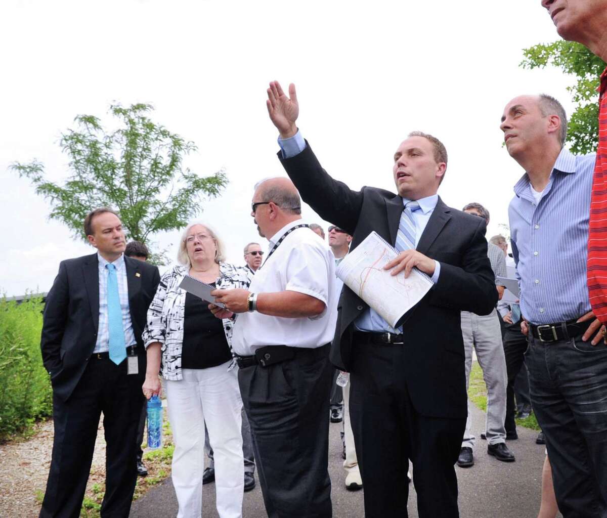 Second from right, Jason Cabral of the firm Burns & McDonnell, an engineering, architecture, and construction firm, leads the Connecticut Siting Council tour of Cos Cob Park in Greenwich, Conn., Thursday, July 13, 2017. At left is Greenwich First Selectman Peter Tesei. The siting council was in town to check out proposed routes for a new substation linked from Railroad Avenue to Cos Cob.