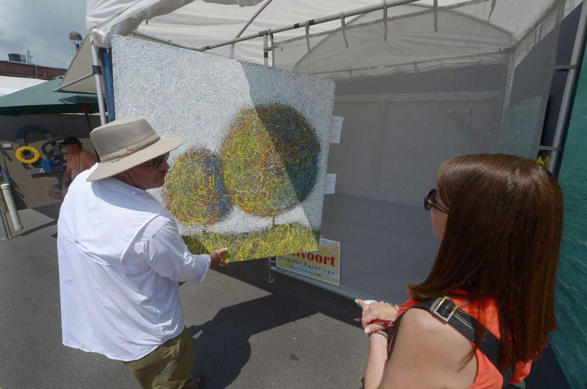 Painter Peter Stolvoort chats with art consultant Mara Arzi during the 44th annual Westport Fine Arts Festival Saturday, July 15, 2017, on Elm Street in Westport, Conn. The Westport Fine Arts Festival featured a premier roster of national and international fine artists across 12 categories and includes over 140 juried artists.