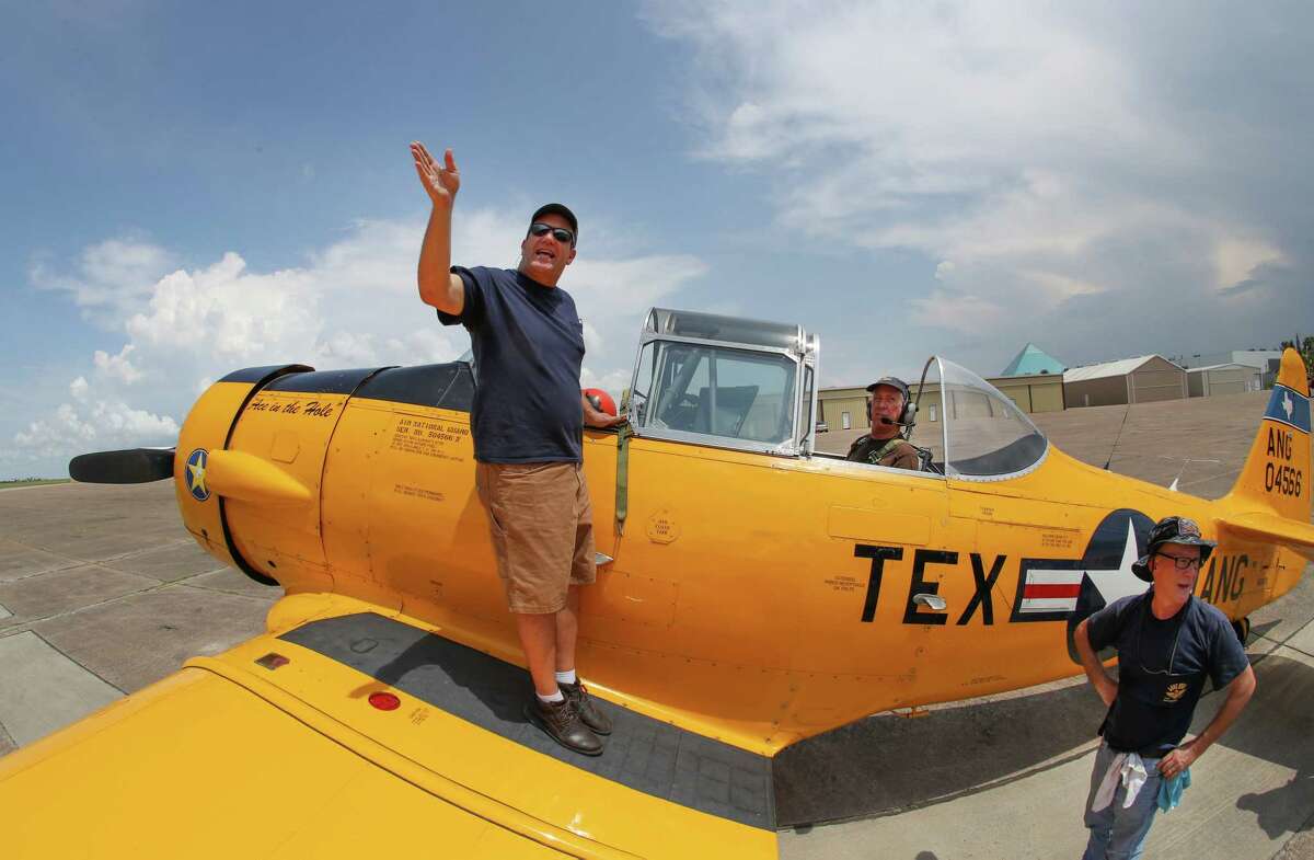 Pilot Charlie Hainline (left) and Plane Captain Kevin McGowan (right) talk to ground personnel before taking Steve Giesler (c) on a flight in a T-6 aircraft at the Lone Star Flight Museum, Saturday, July 15, 2017, in Galveston. The LSFM will close its doors on the Galveston location July 15th and will thank the Galveston community with a farewell event. This all-day event is an opportunity for media to tour the Galveston museum one last time and meet the volunteers, staff and pilots who are helping create an all new LSFM experience at Ellington Airport. ( Steve Gonzales / Houston Chronicle )