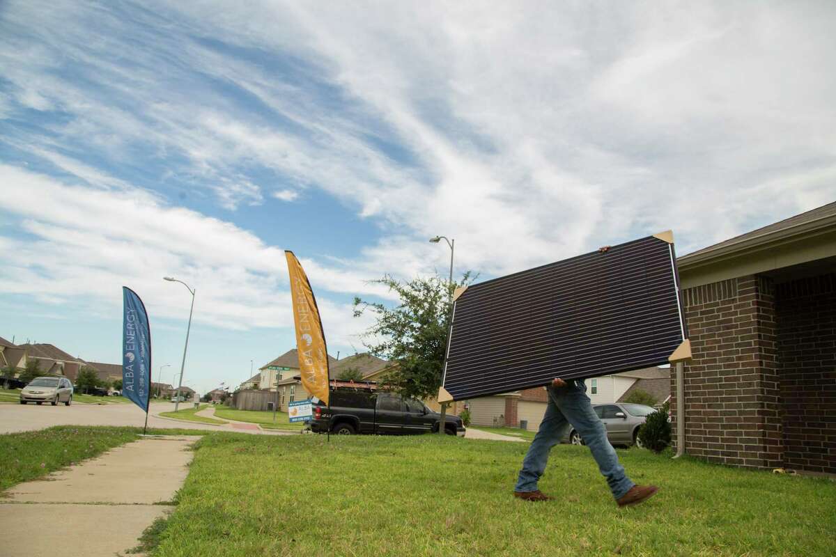 Workers from Alba Energy install solar panels on a home in Upland Spring Terrace in Katy.