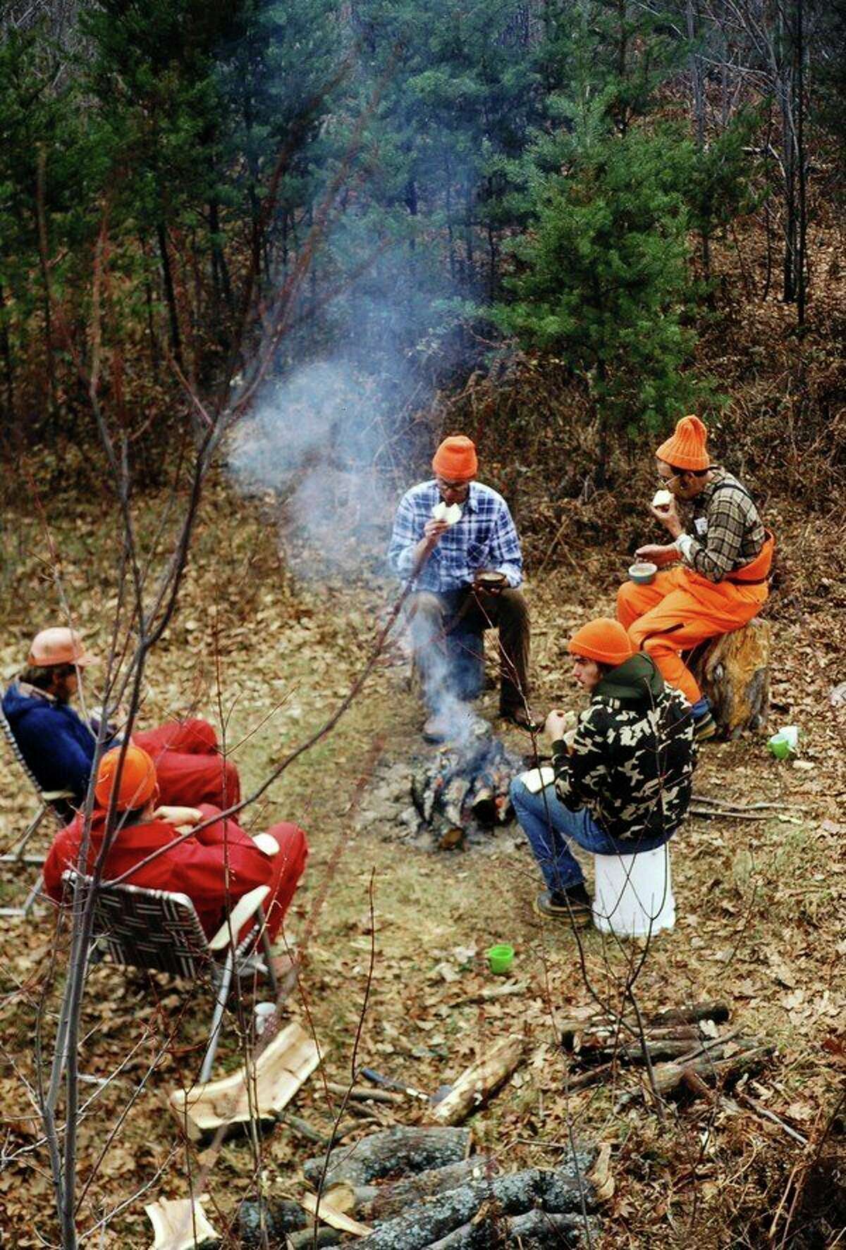  Hunters sit around a deer-camp campfire. (Steve Griffin/file photo for the Daily News)