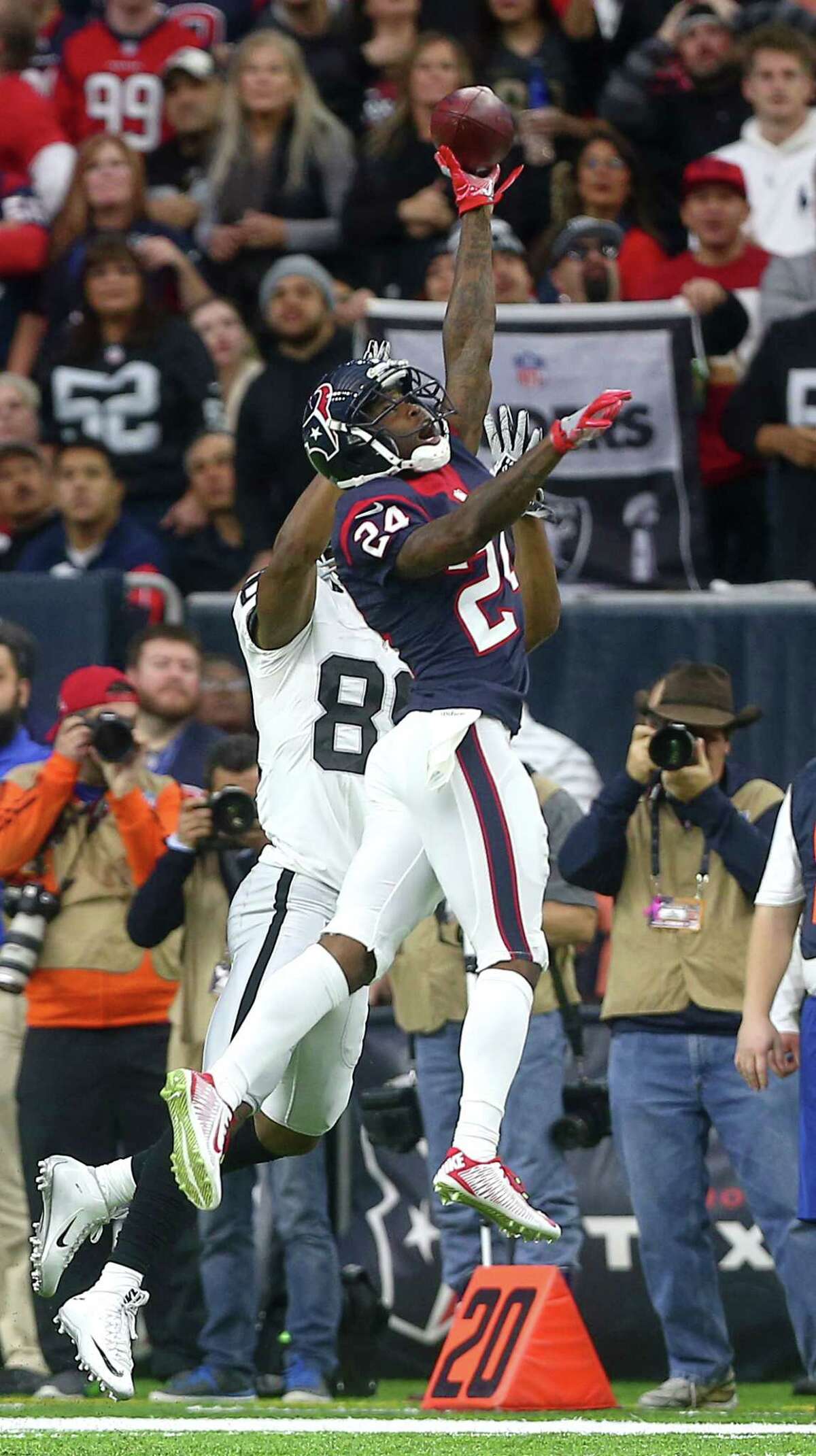 Texans cornerback Johnathan Joseph, right, deflects a pass intended for the Raiders' Amari Cooper in the playoff game. Joseph had 45 tackles and defensed nine passes last season.﻿