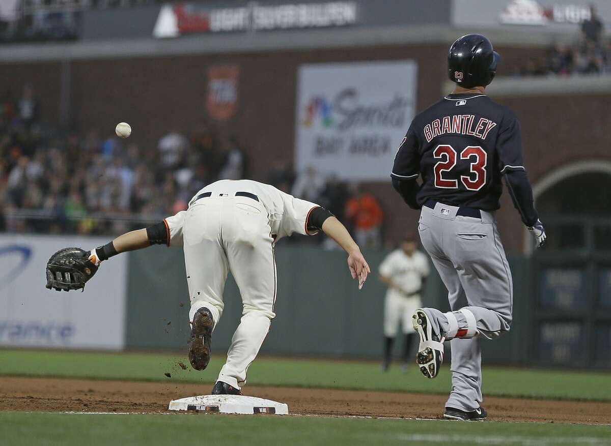 Cleveland Indians' Michael Brantley, right, reaches first base for a single as San Francisco Giants first baseman Jae-Gyun Hwang, left, reaches for the throw during the fifth inning of a baseball game Monday, July 17, 2017, in San Francisco. (AP Photo/Eric Risberg)
