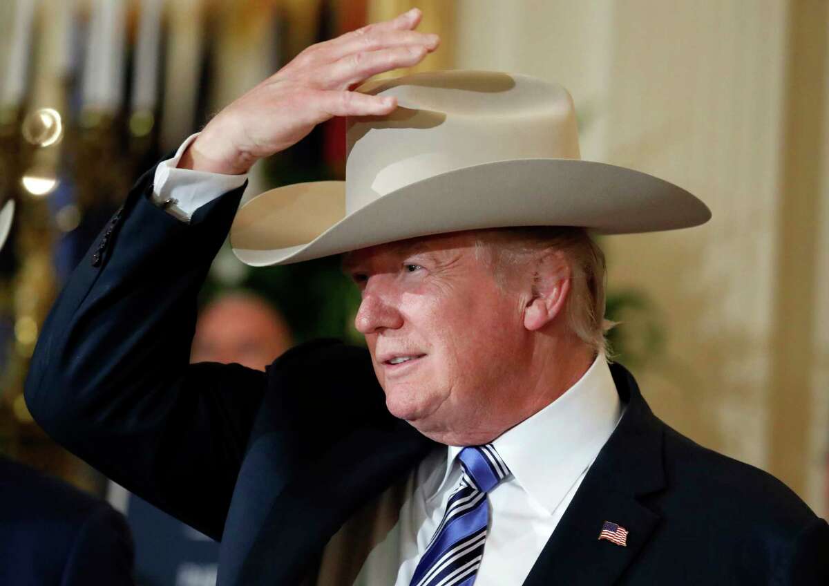 President Donald Trump tries on a Stetson hat during a "Made in America," product showcase featuring items created in each of the U.S. 50 states, Monday, July 17, 2017, at the White House in Washington. Stetson is base in Garland, Texas. (AP Photo/Alex Brandon)