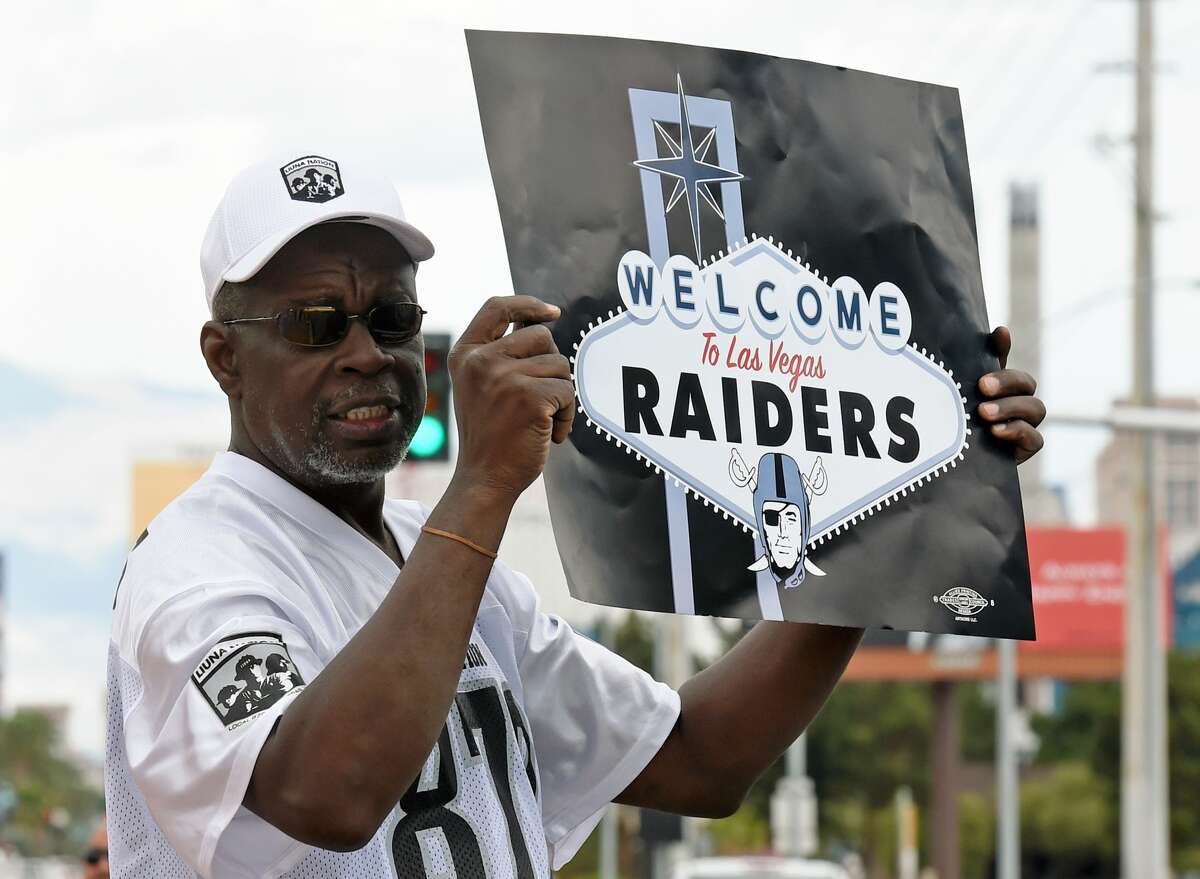 Oakland Raiders fan Davi Tole of Nevada displays a sign to passing motorists on the Las Vegas Strip after NFL owners voted 31-1 to approve the team's application to relocate to Las Vegas.
