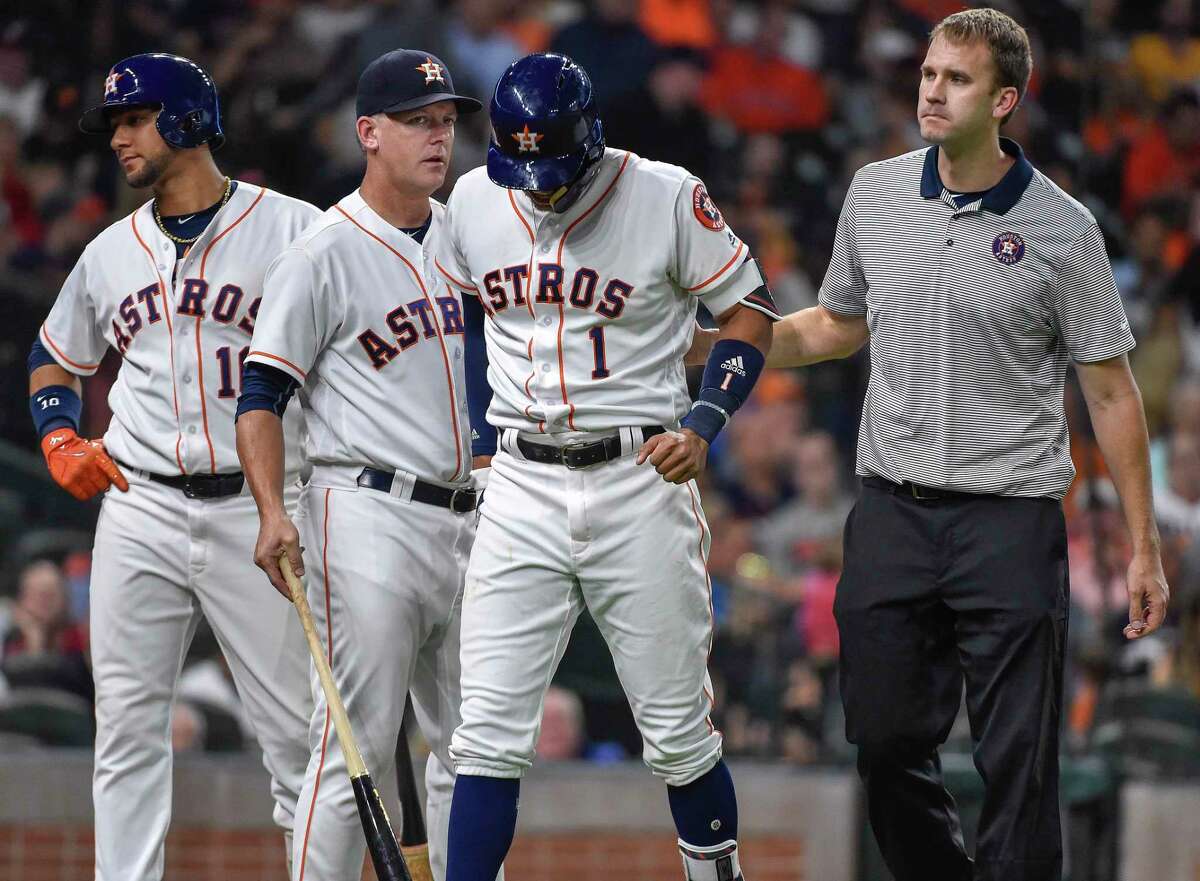 Houston Astros' Carlos Correa (1) walks off the field with manager AJ Hinch, second from left, after an injury during the fourth inning of the team's baseball game against the Seattle Mariners, Monday, July 17, 2017, in Houston. (AP Photo/Eric Christian Smith)