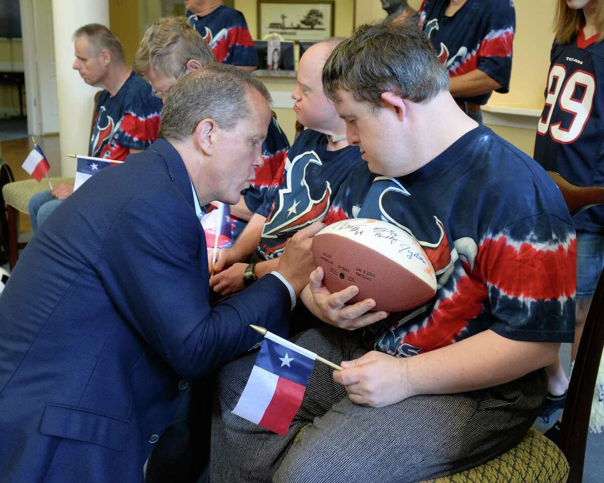 Houston Texans President Jamey Rootes signs an autograph for a resident of the Brookwood Community as Special Teams for Special Needs, a collaboration between the Houston Texans and Mustang Cat, present the Brookwood Community with a donation of $60,000 at the Brookwood Community in Brookshire, TX on July 11, 2017.