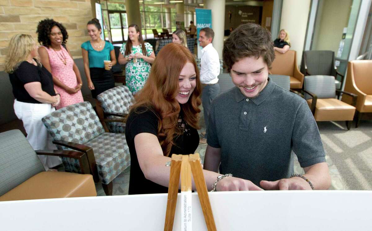 CJ, right, and Morgan Mote, both with cystic fibrosis, share a laugh as they reflect on images from CJ's trip to the Ebisu Drift School in Japan during a reception with friends, family and hospital staff at CHI St. LukeÃ©?•s Lakeside Hospital, Tuesday, July 18, 2017, in The Woodlands. Spinal Elements created a $125,000 endowment in honor of Mike Leahy, a local spine surgeon, to benefit the Make-A-Wish Texas Gulf Coast and Louisiana chapter. Leahy has generated nearly $200,000 in donations through the program, which resulted in 25 kids, including CJ, receiving their wish through the Make-A-Wish foundation.