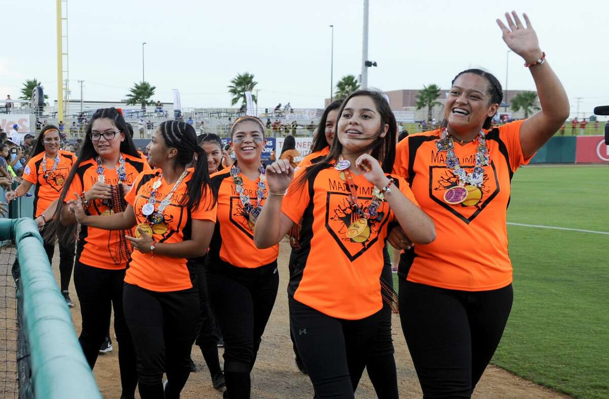 Softball players from across South Texas wave and toss out beads as they take a lap around Uni-Trade Stadium on Tuesday, July 18, 2017 during the opening ceremony of the PONY League Softball World Series.
