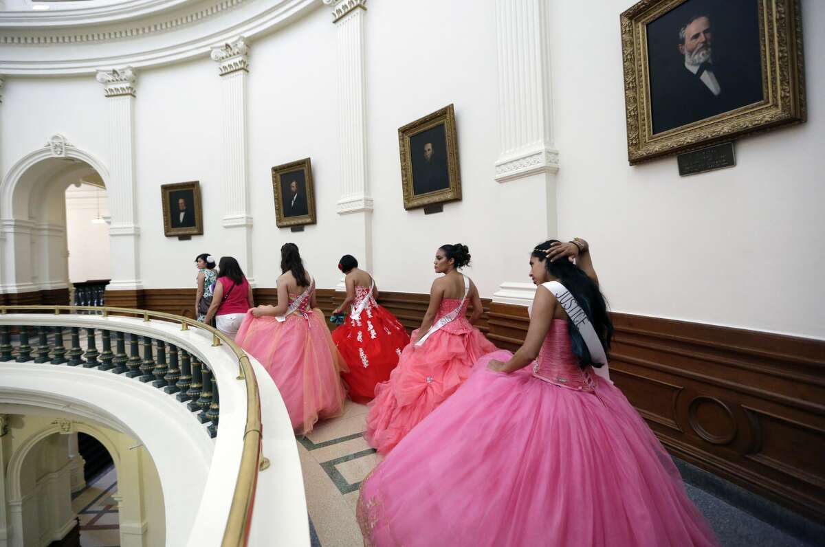 Young women dressed as Quinceaneras walk through the Texas Capitol to visit lawmakers as they protest SB4, an anti-"sanctuary cities" bill, in Austin, Texas, Wednesday, July 19, 2017. The "sanctuary cities" ban, signed in May, lets police ask people during routine stops whether they're in the U.S. legally. (AP Photo/Eric Gay)