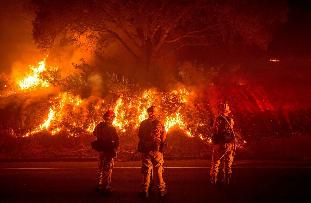 Firefighters monitor flames on the side of a road as the Detwiler fire rages on near the town of Mariposa, California on July 18, 2017. California has suffered widespread fires in recent days, with a lighting strike near Yosemite National Park sparking a blaze that destroyed more than 26 square kilometers (10 square miles) of forest. / AFP PHOTO / JOSH EDELSONJOSH EDELSON/AFP/Getty Images
