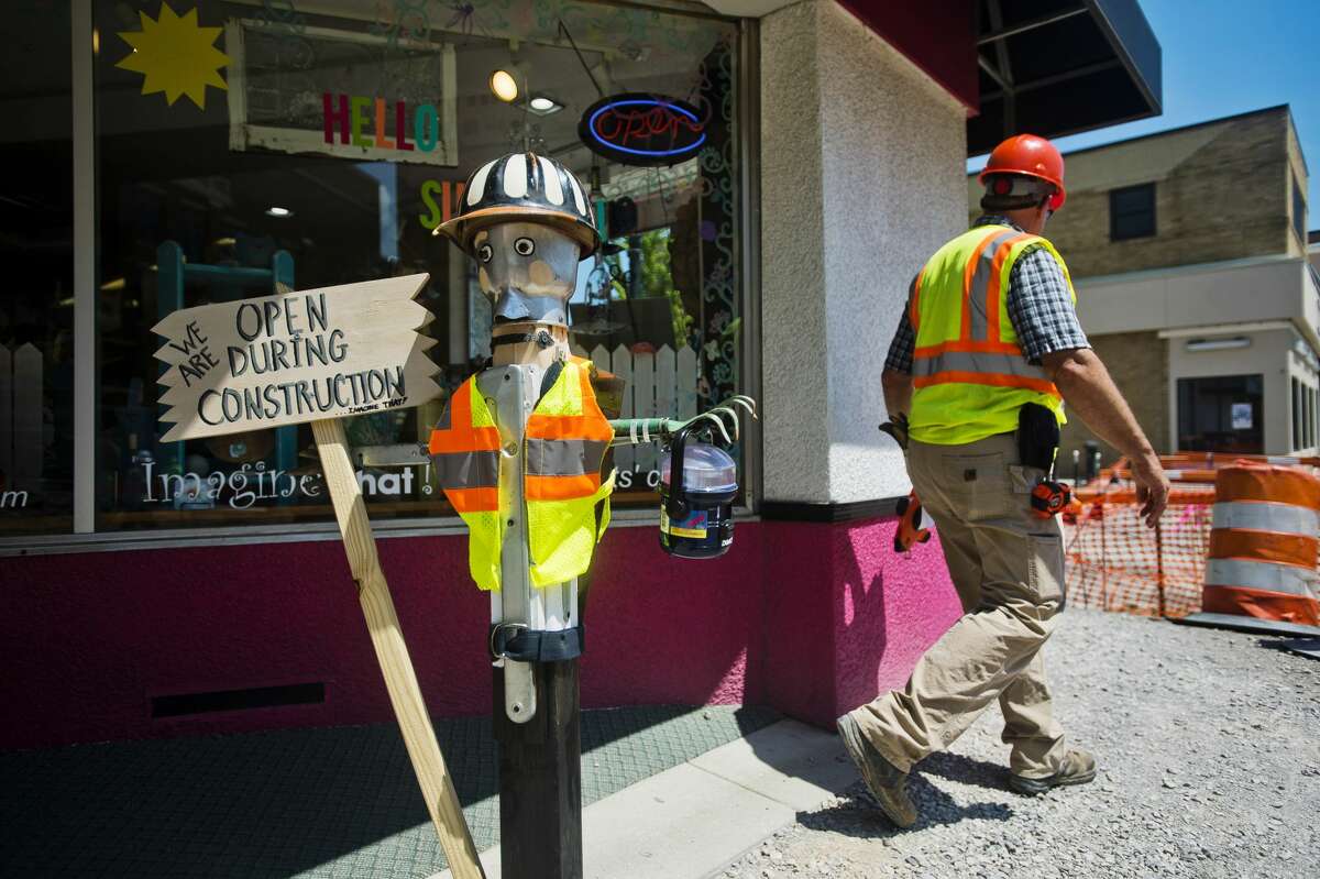 Project Manager Dennis Lauer walks past Imagine That! and a construction worker mannequin in front of the store as crews work on the Main Street streetscape project on Thursday. Businesses on Main Street will remain open as work is done to update sidewalks, street lighting, landscaping and irrigation.