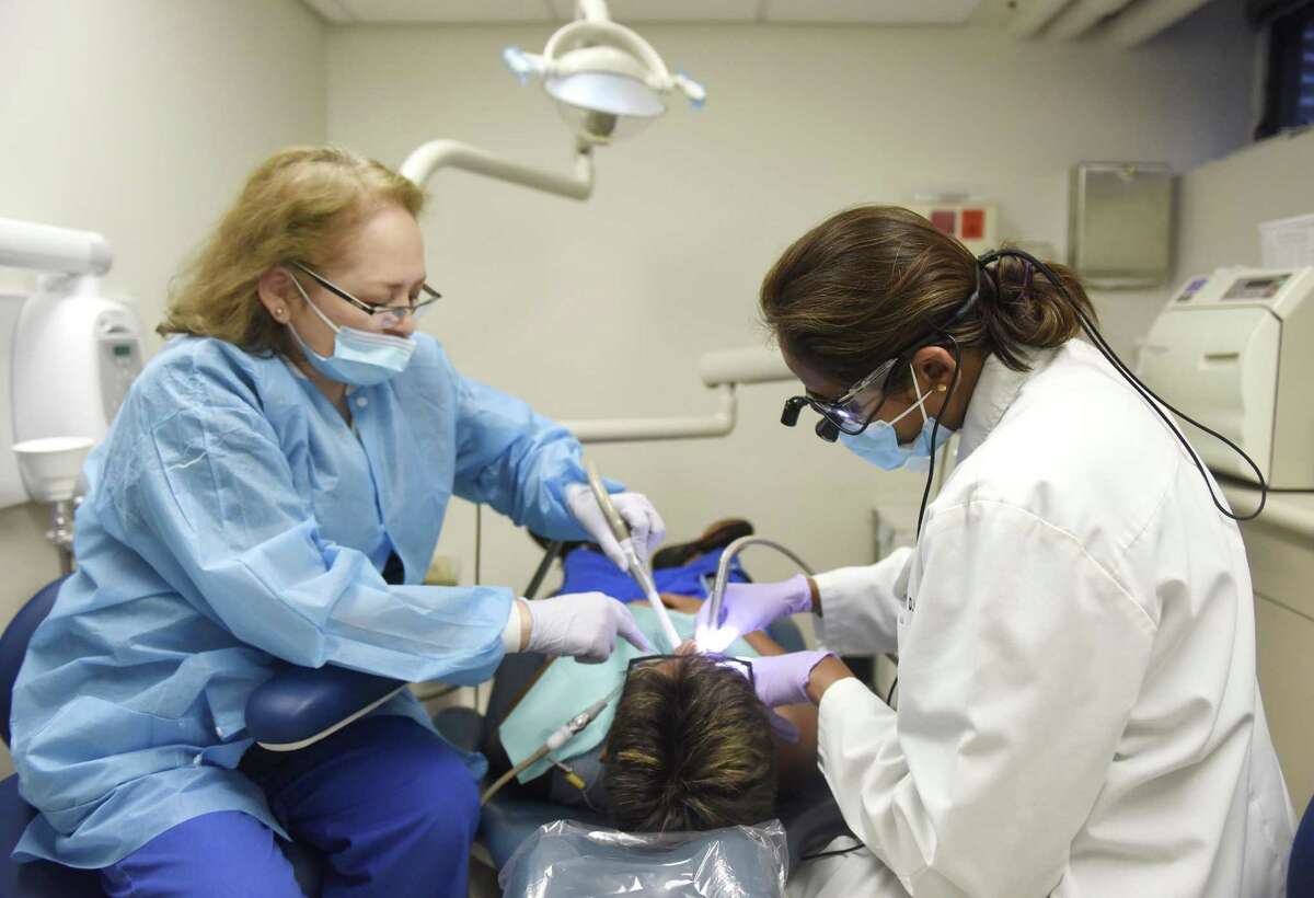 Dental assistant Monica Padilla, left, helps Dr. Ishrat Rangwala during a dental exam at Family Centers Health Care clinic located in the Wilbur Peck Court housing complex in Greenwich, Conn. Wednesday, July 19, 2017. The clinic, which offers health care, dental and mental health services, is celebrating its first year anniversary.