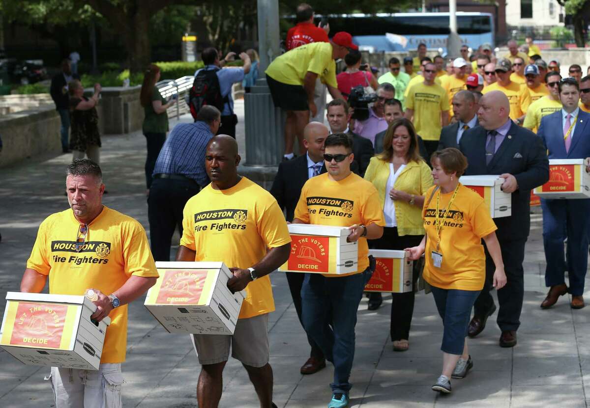 Houston firefighters deliver boxes of more than 32,000 signatures to City Hall on Monday asking voters in November to mandate parity in pay between firefighter and police officer ranks.