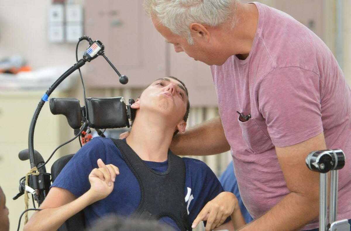 Brett Davis stops by to see his son Wyatt who suffers with cerebral palsy while he sits with others during a craft program at Star's facility on Monday July 17, 2017 in Norwalk Conn. Star and its client families will be directly impacted by the six furlough days ordered by the state when no services will be available on those days.