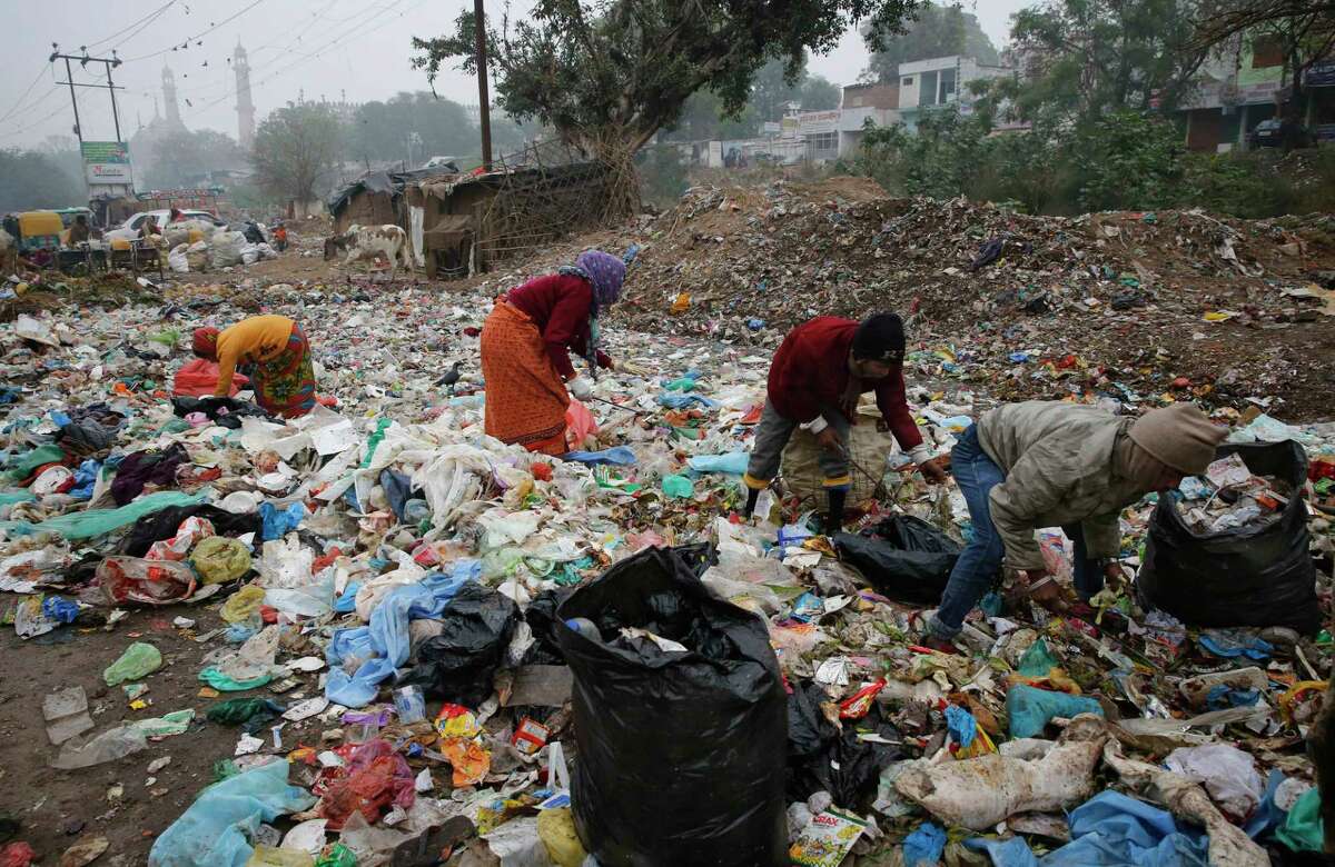 FILE - In this Jan. 21, 2016 file photo, Indian rag pickers look for reusable materials at a garbage dump littered with polythene bags in Lucknow, India. A new massive study finds that production of plastic and the hard-to-breakdown synthetic waste is soaring in huge numbers. The study says since 1950, industry has made more than 9 billion tons of plastics. ThatÂ?’s enough to cover the entire country of Argentina ankle deep in the stuff. (AP Photo/Rajesh Kumar Singh)